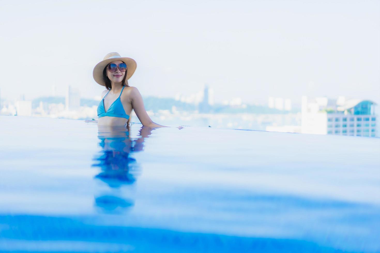 Retrato hermosas mujeres asiáticas jóvenes sonrisa feliz relajarse piscina al aire libre en el resort foto