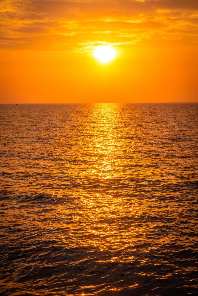hermosa puesta de sol en la playa y el mar foto
