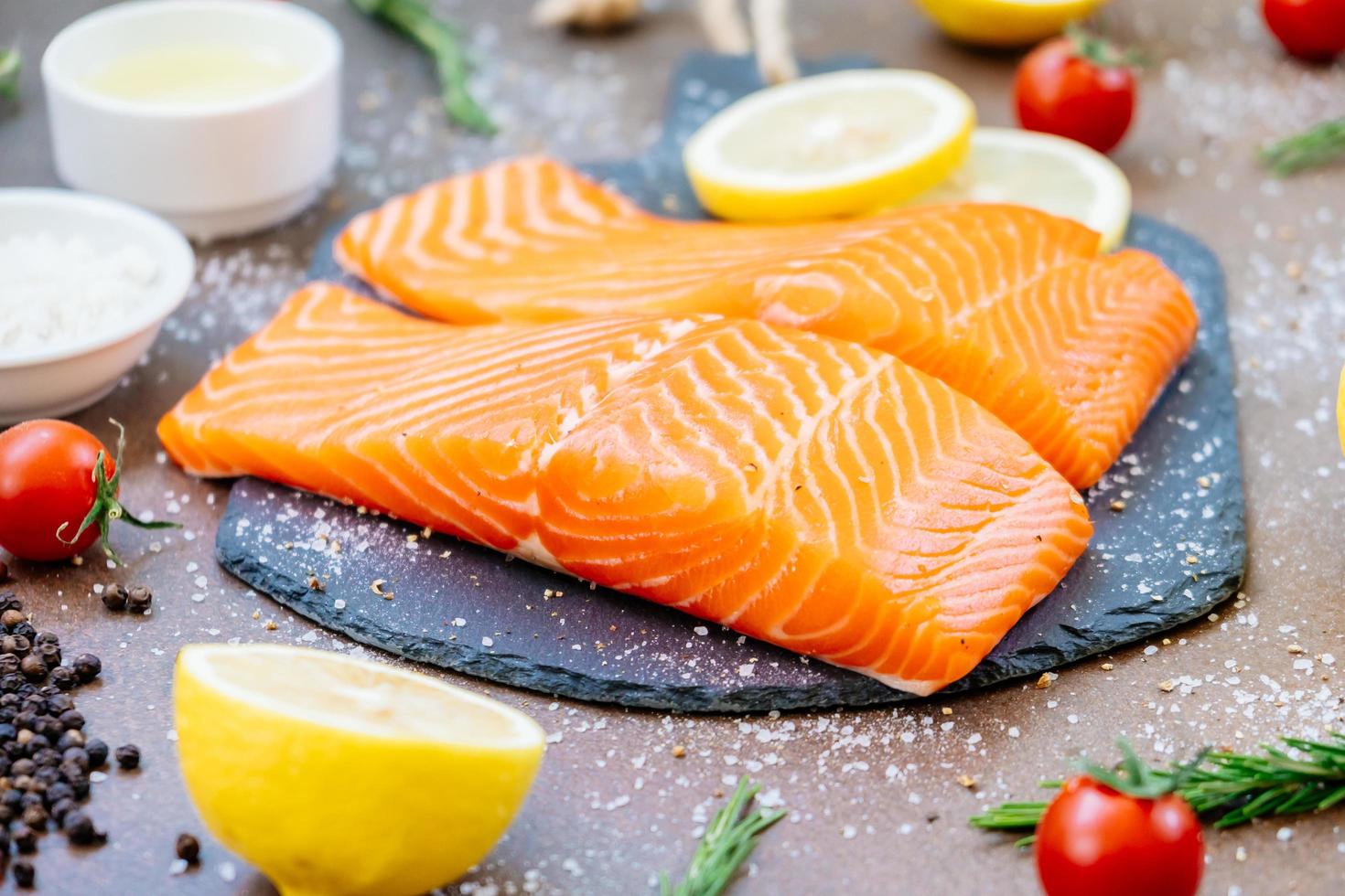 Raw and fresh salmon meat fillet on black stone slate photo