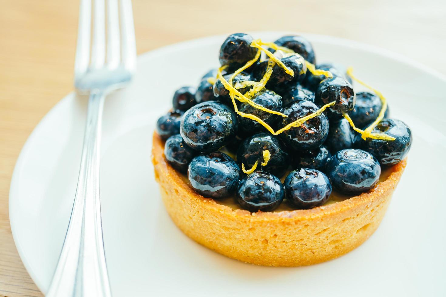 Sweet dessert with blueberry tart in white plate photo