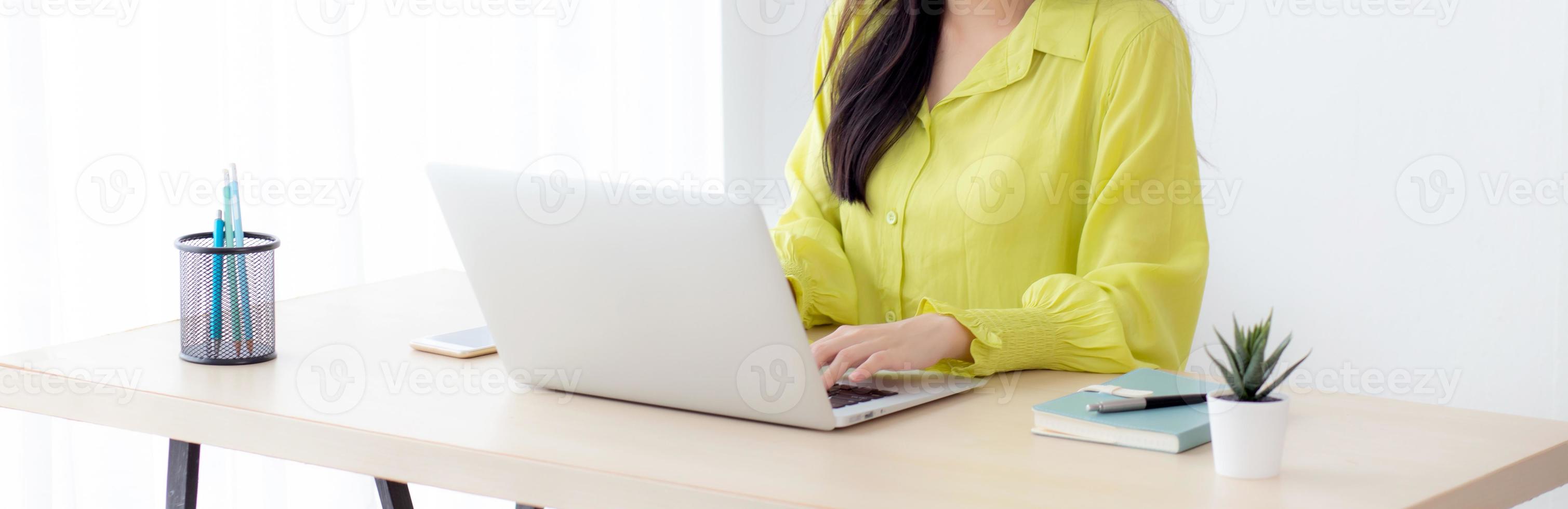 Young asian businesswoman working on laptop computer on desk at home office, freelance looking and typing on notebook on table, lifestyle of woman studying online, business and education concept. photo