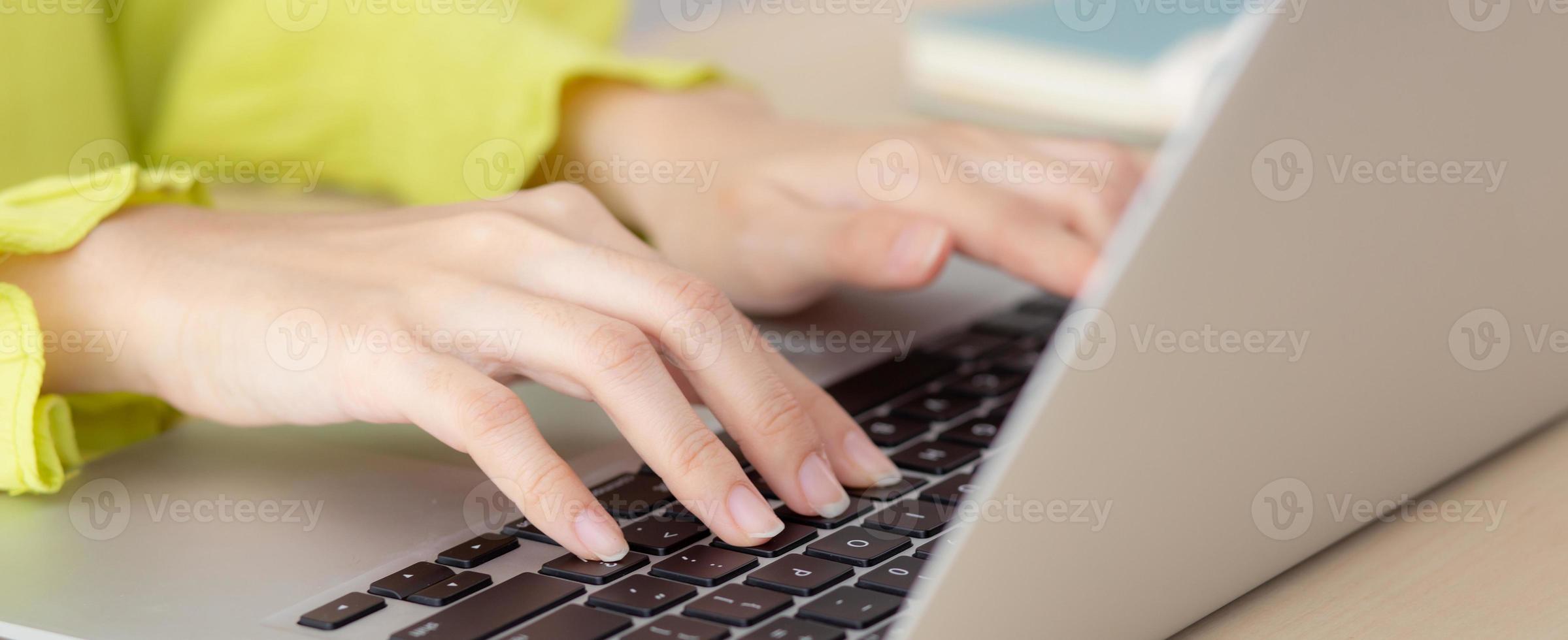 Closeup of hand young asian businesswoman working on laptop computer on desk at home office, freelance looking and typing on notebook on table, woman studying online, business and education concept. photo