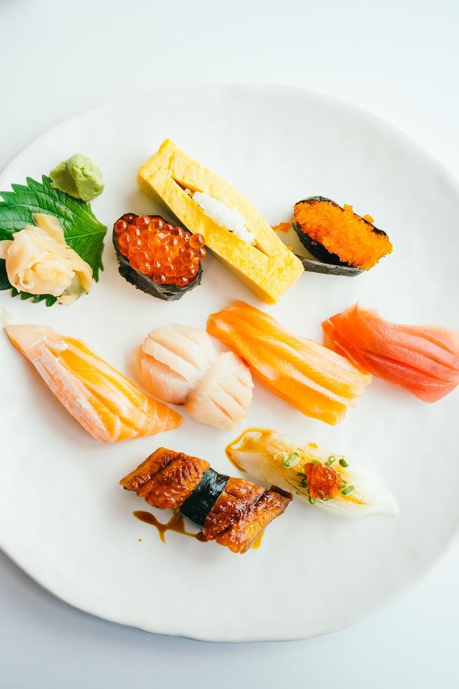 Sushi nigiri crudo y fresco en placa blanca. foto