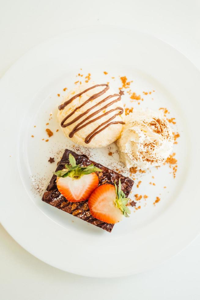 Vanilla ice cream with chocolate brownie cake with strawberry on top photo