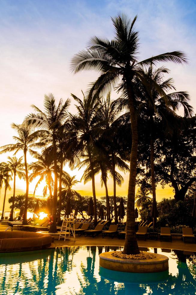 Silueta de palmera de coco alrededor de la piscina foto