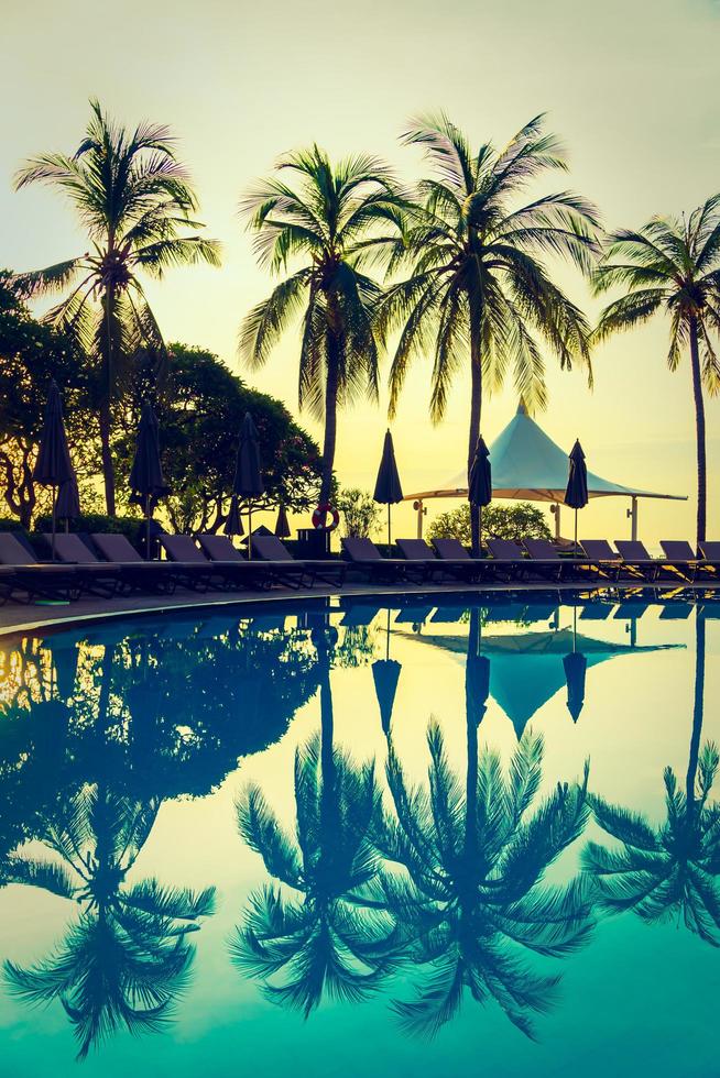 Silhouette coconut palm tree around swimming pool photo