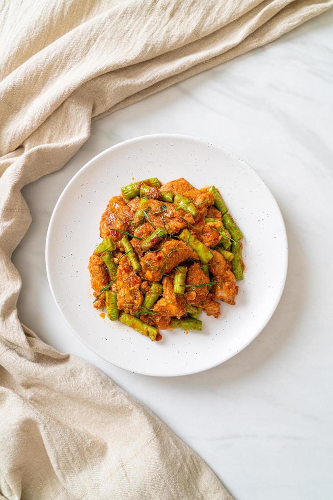 salteado de cerdo frito y pasta de curry rojo con frijoles picantes foto