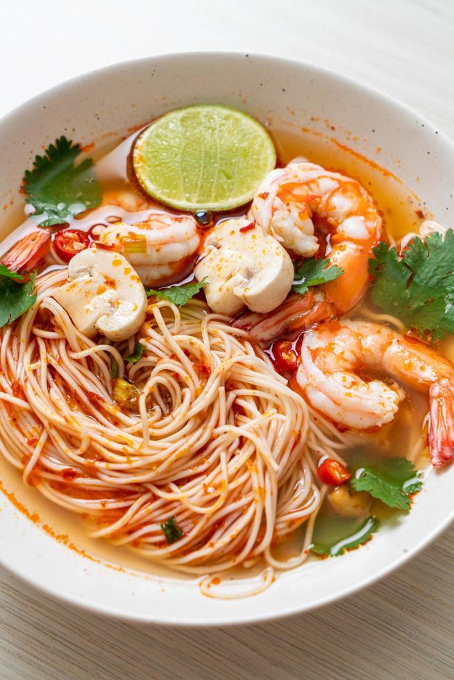 Noodles with spicy soup and shrimps in white bowl, or Tom Yum Kung - Asian food style photo