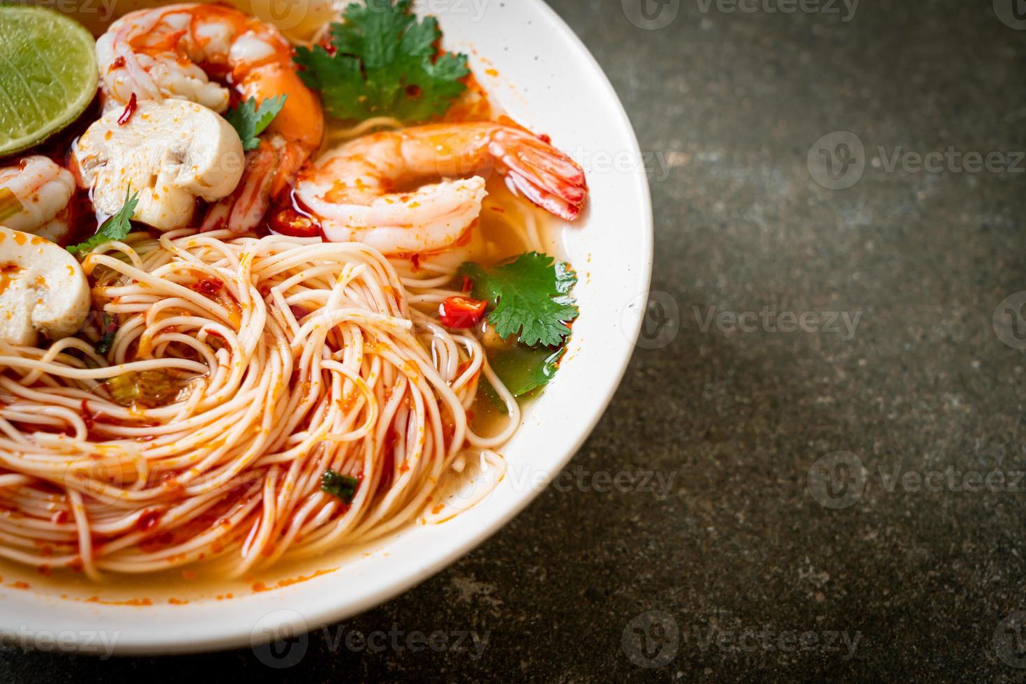 fideos con sopa picante y camarones en un tazón blanco, o tom yum kung - estilo de comida asiática foto