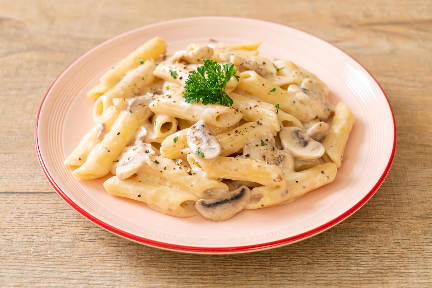 Penne pasta carbonara cream sauce with mushroom - Italian food style photo