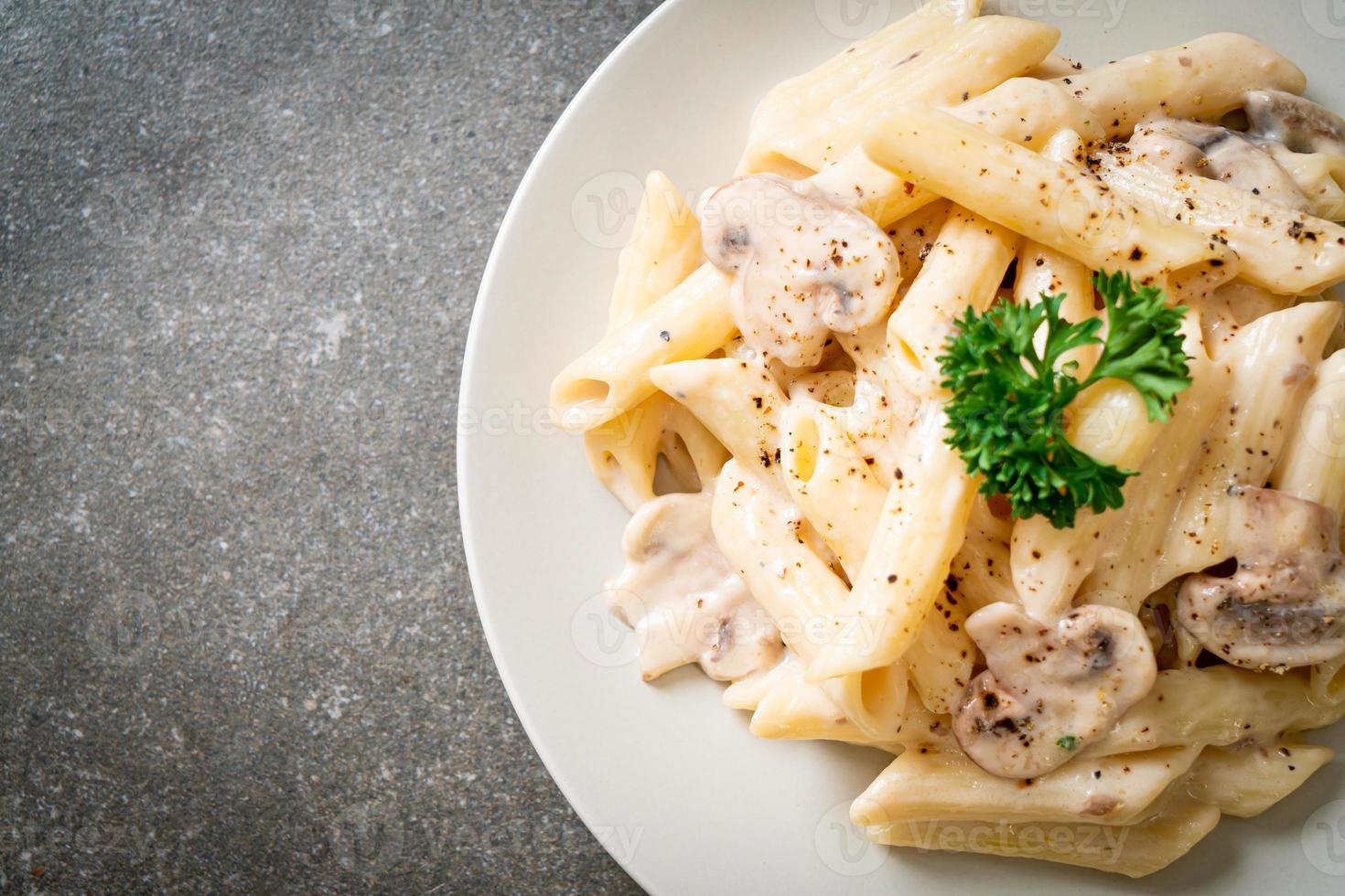 Penne pasta carbonara cream sauce with mushroom - Italian food style photo