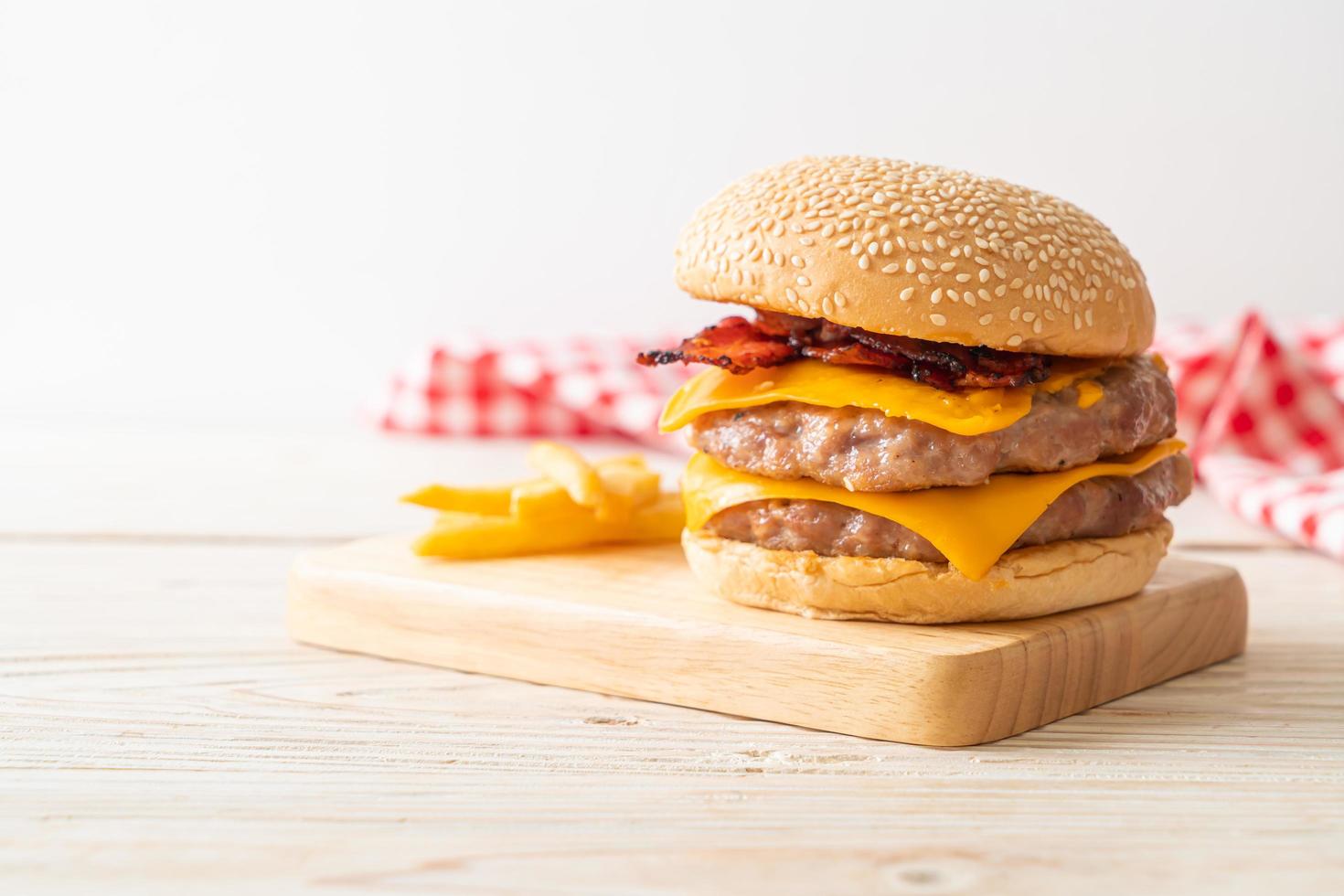 hamburguesa de cerdo o hamburguesa de cerdo con queso, tocino y papas fritas foto