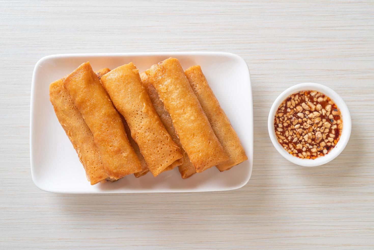 Deep-fried spring roll with sauce on white plate photo