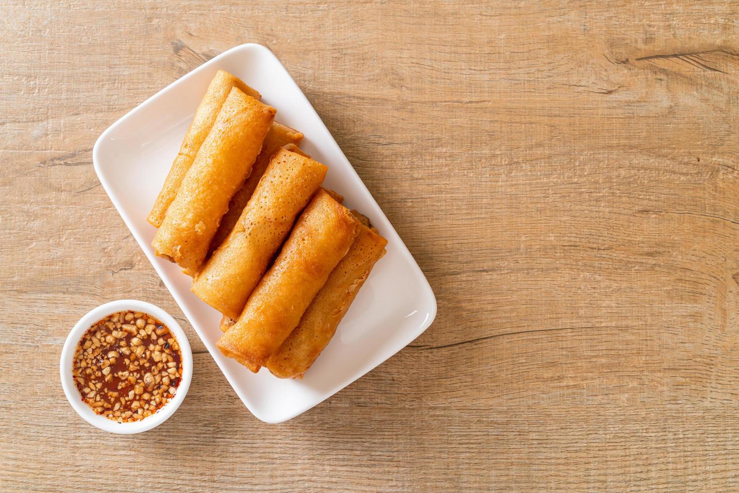 Rollito de primavera frito con salsa en la placa blanca. foto