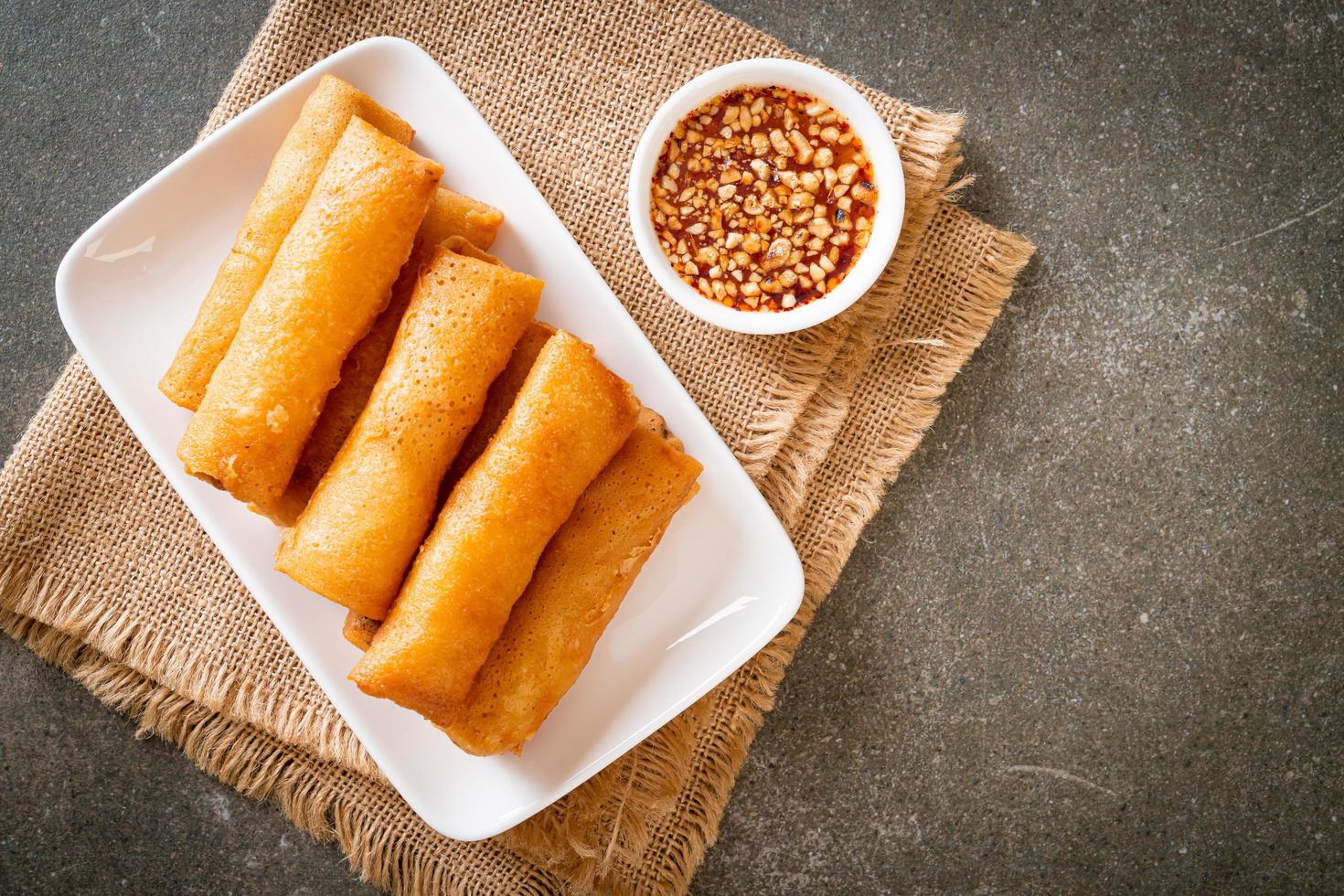 Rollito de primavera frito con salsa en la placa blanca. foto