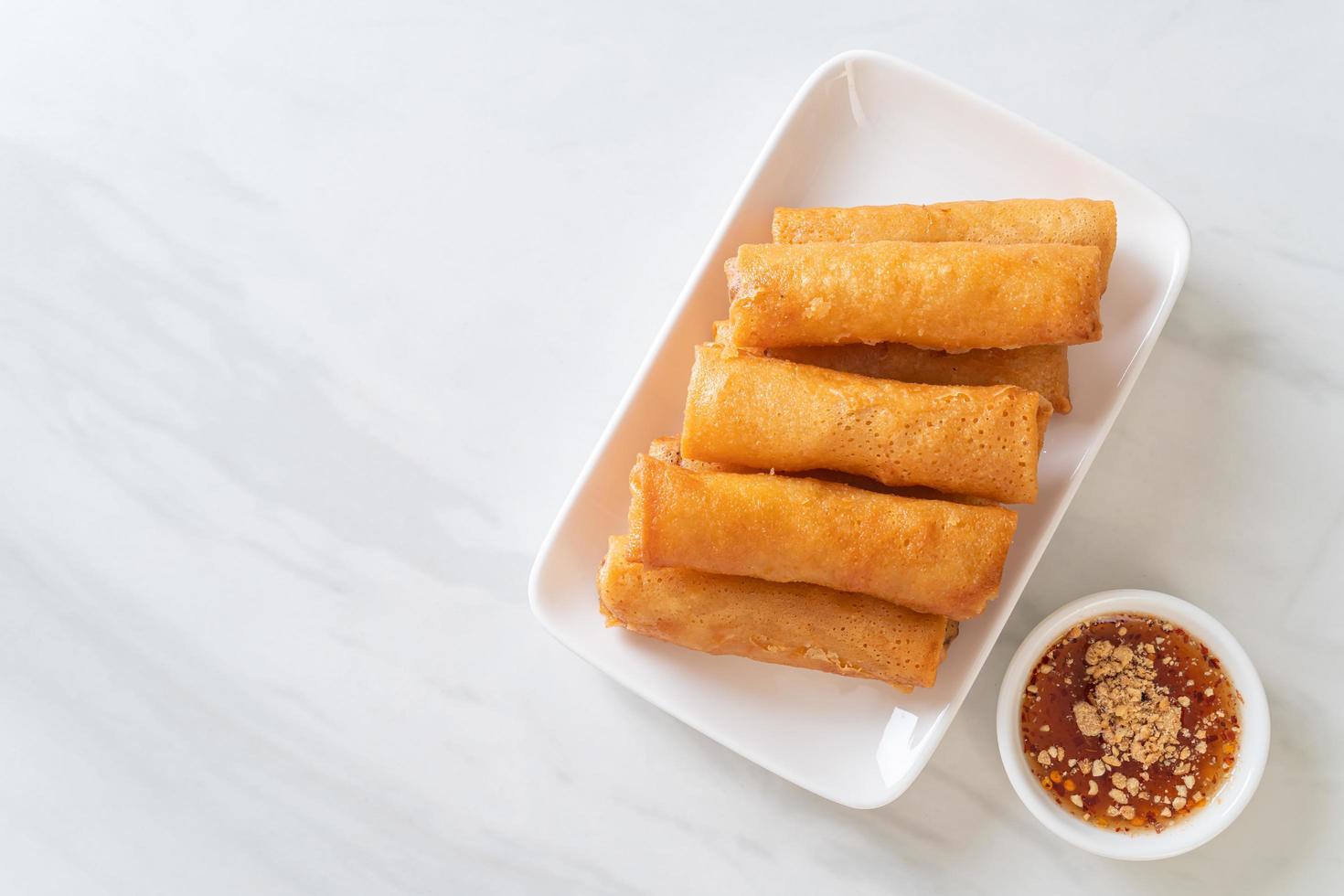 Deep-fried spring roll with sauce on white plate photo