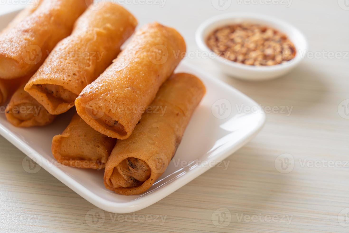 Deep-fried spring roll with sauce on white plate photo