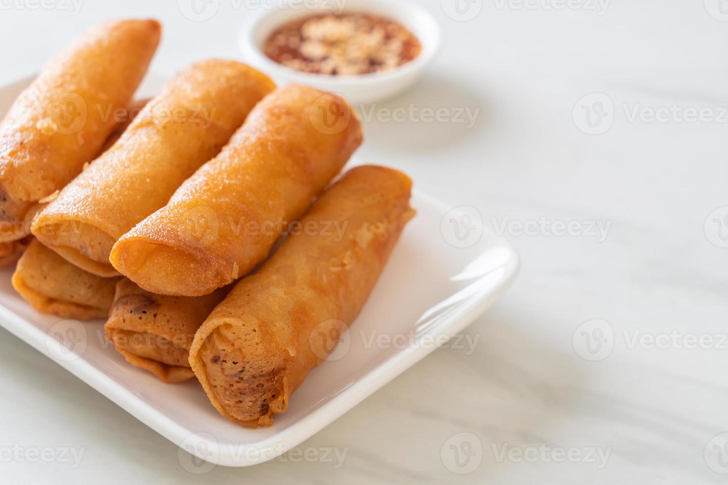 Deep-fried spring roll with sauce on white plate photo