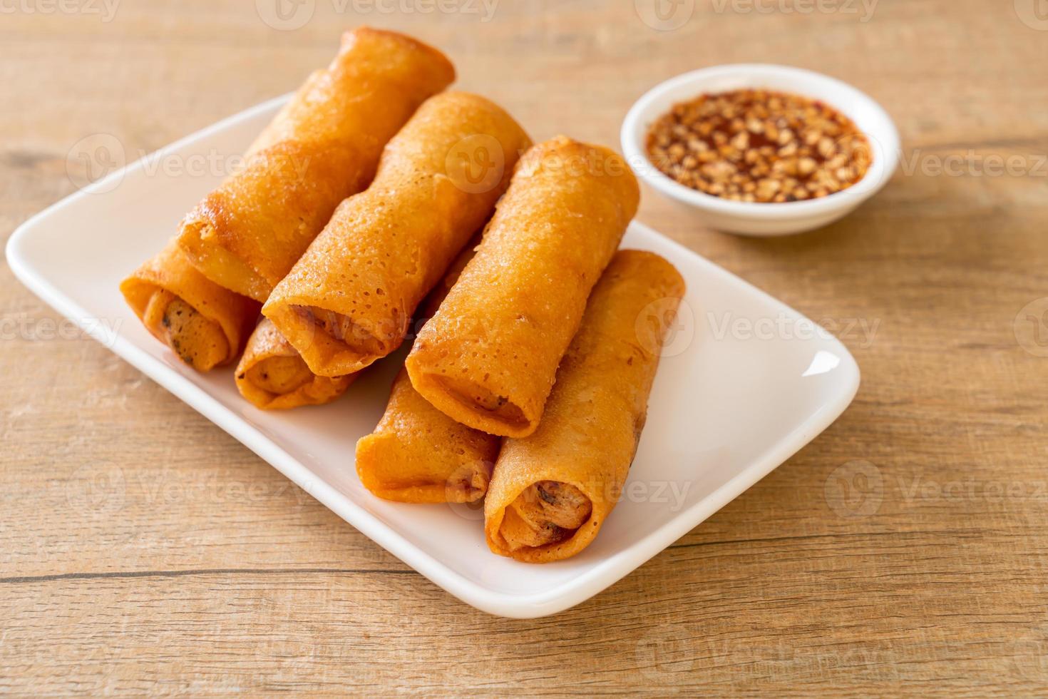 Deep-fried spring roll with sauce on white plate photo