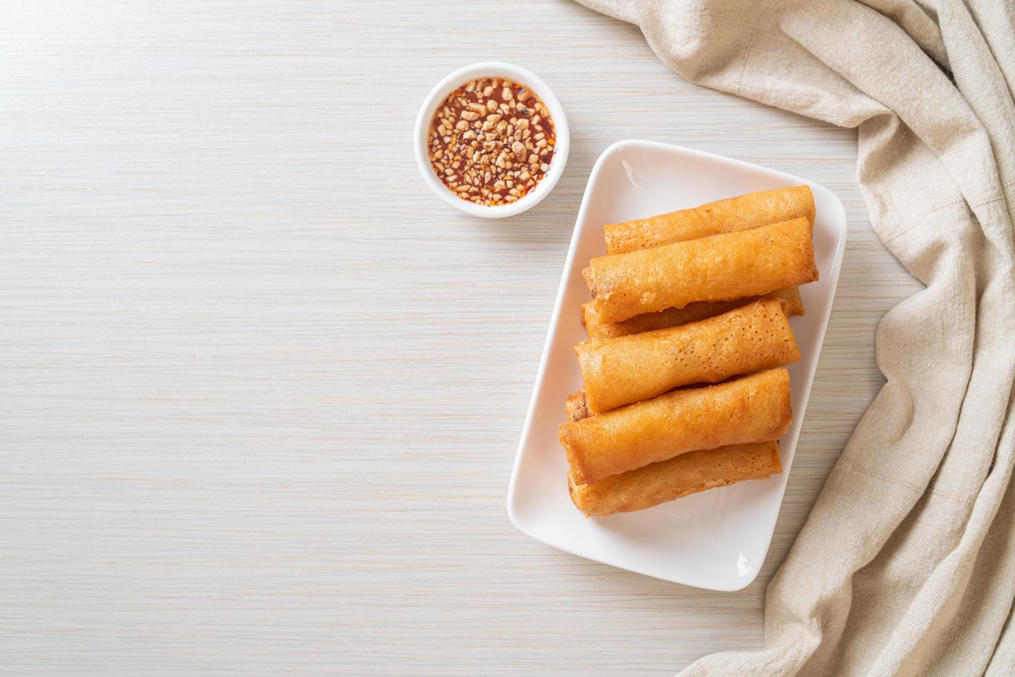 Deep-fried spring roll with sauce on white plate photo