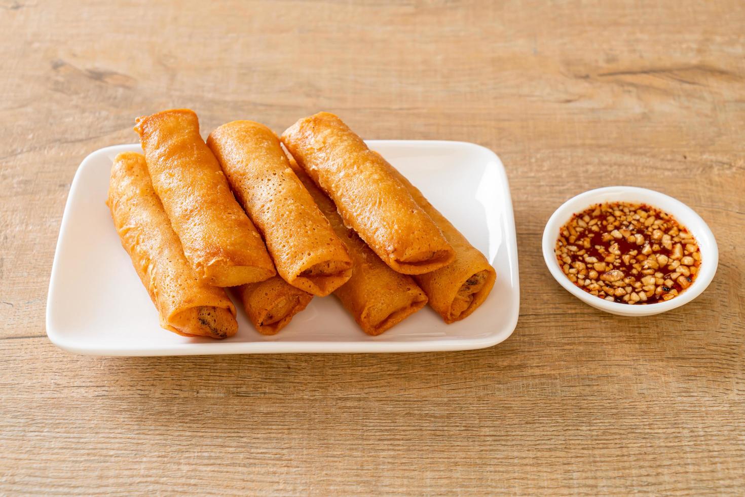 Rollito de primavera frito con salsa en la placa blanca. foto