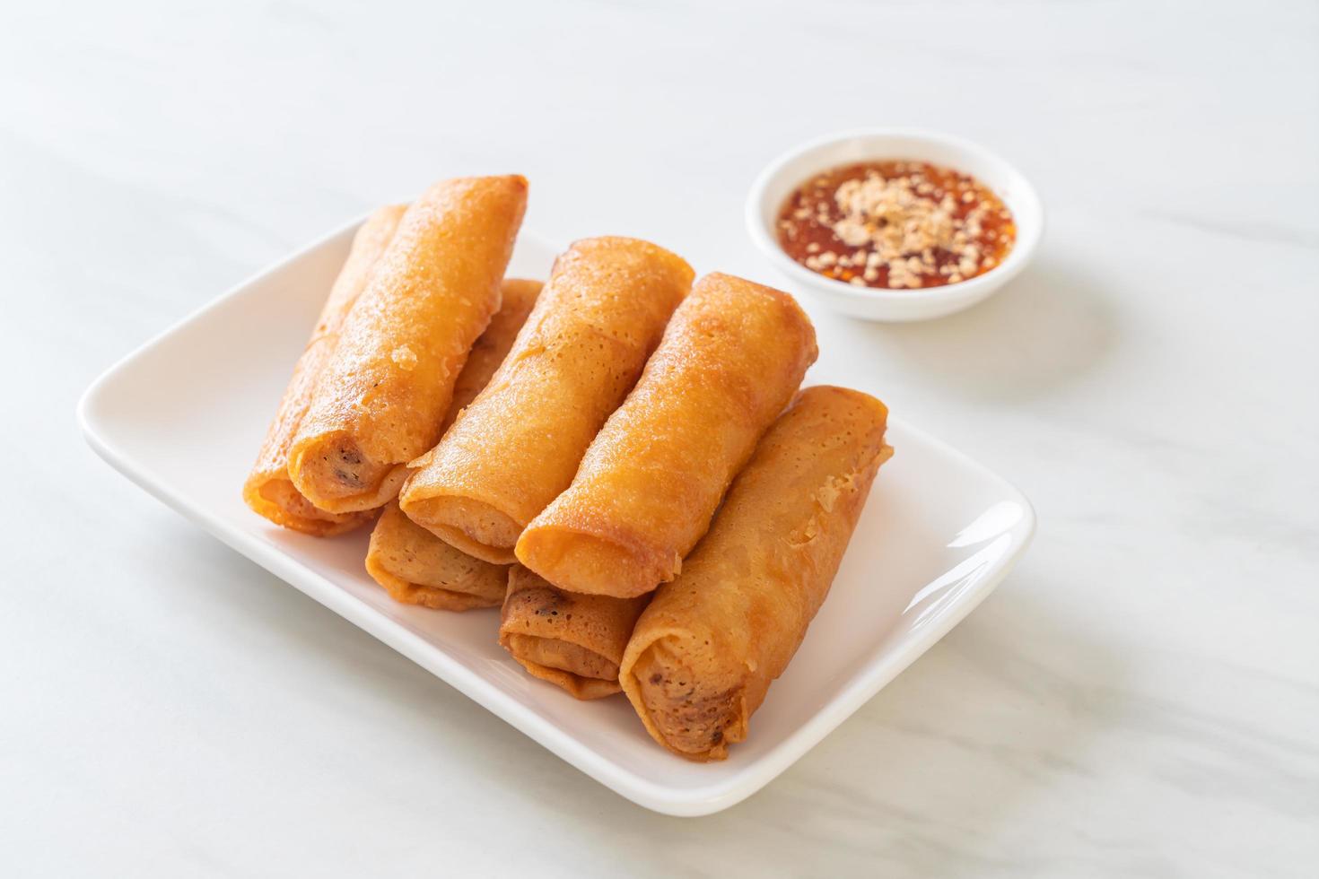 Deep-fried spring roll with sauce on white plate photo