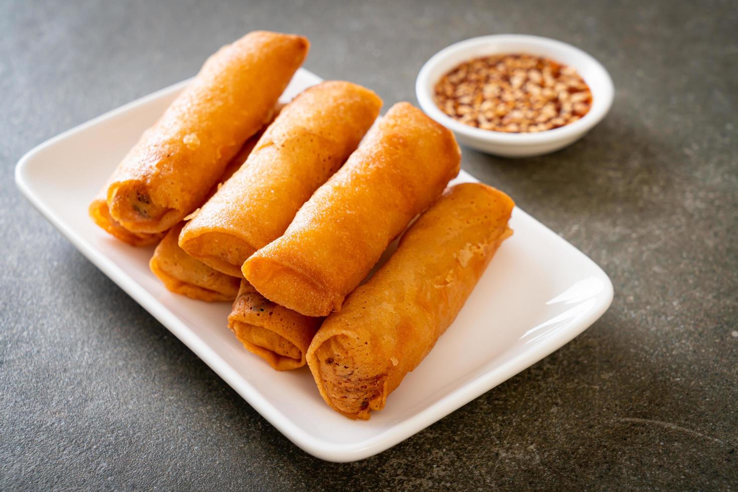 Deep-fried spring roll with sauce on white plate photo
