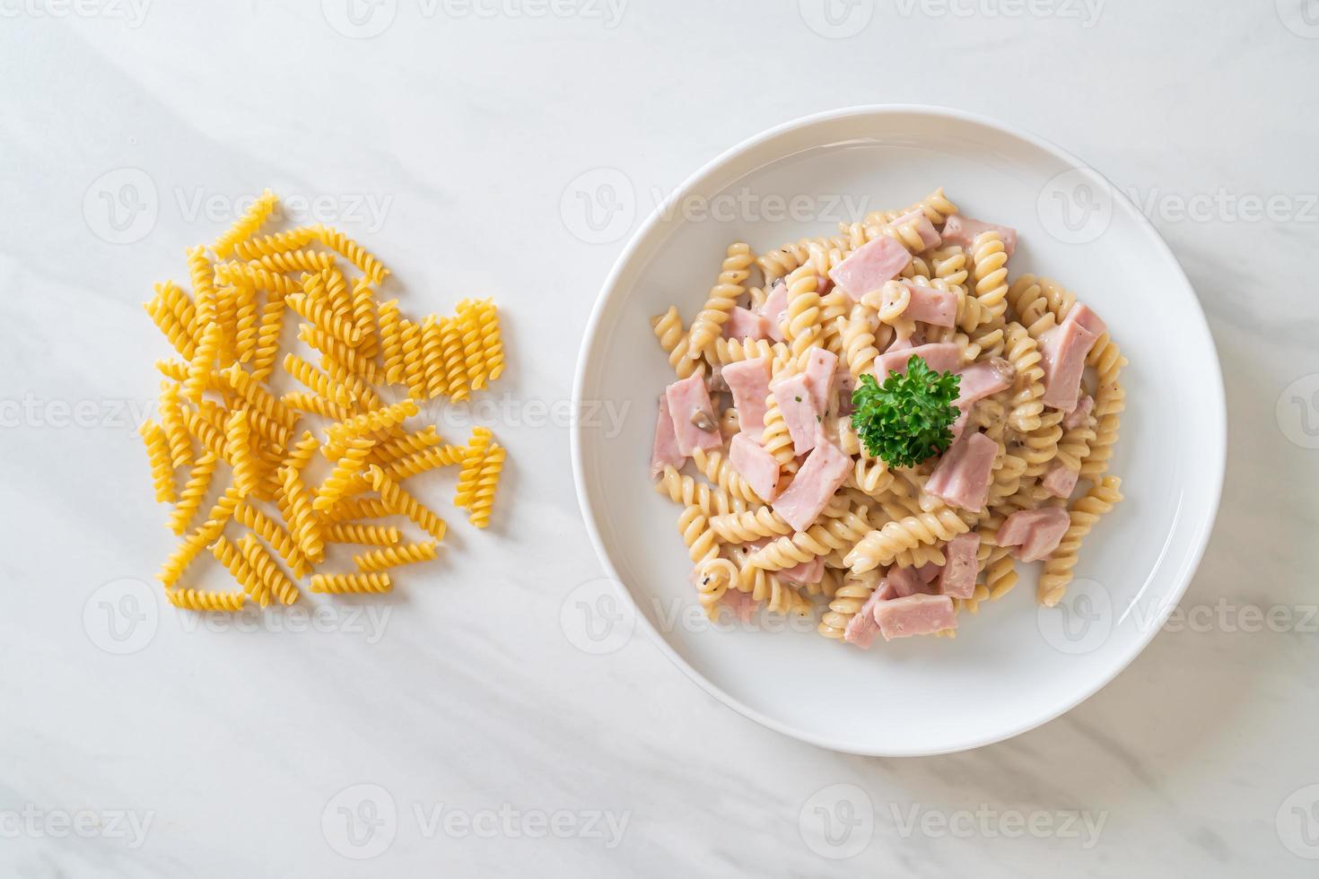 Spirali o salsa de crema de champiñones de pasta con jamón - estilo de comida italiana foto