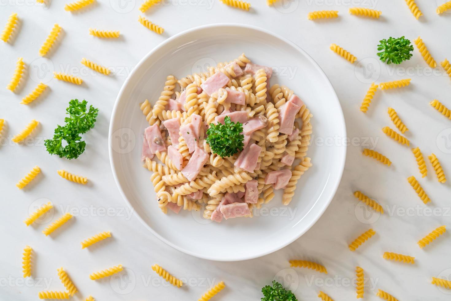 Spirali o salsa de crema de champiñones de pasta con jamón - estilo de comida italiana foto