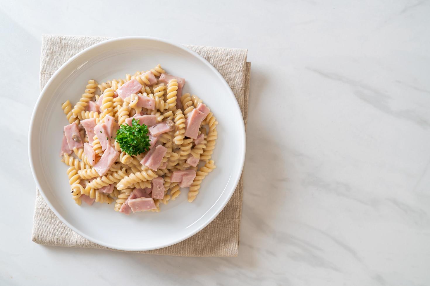 Spirali or spiral pasta mushroom cream sauce with ham - Italian food style photo