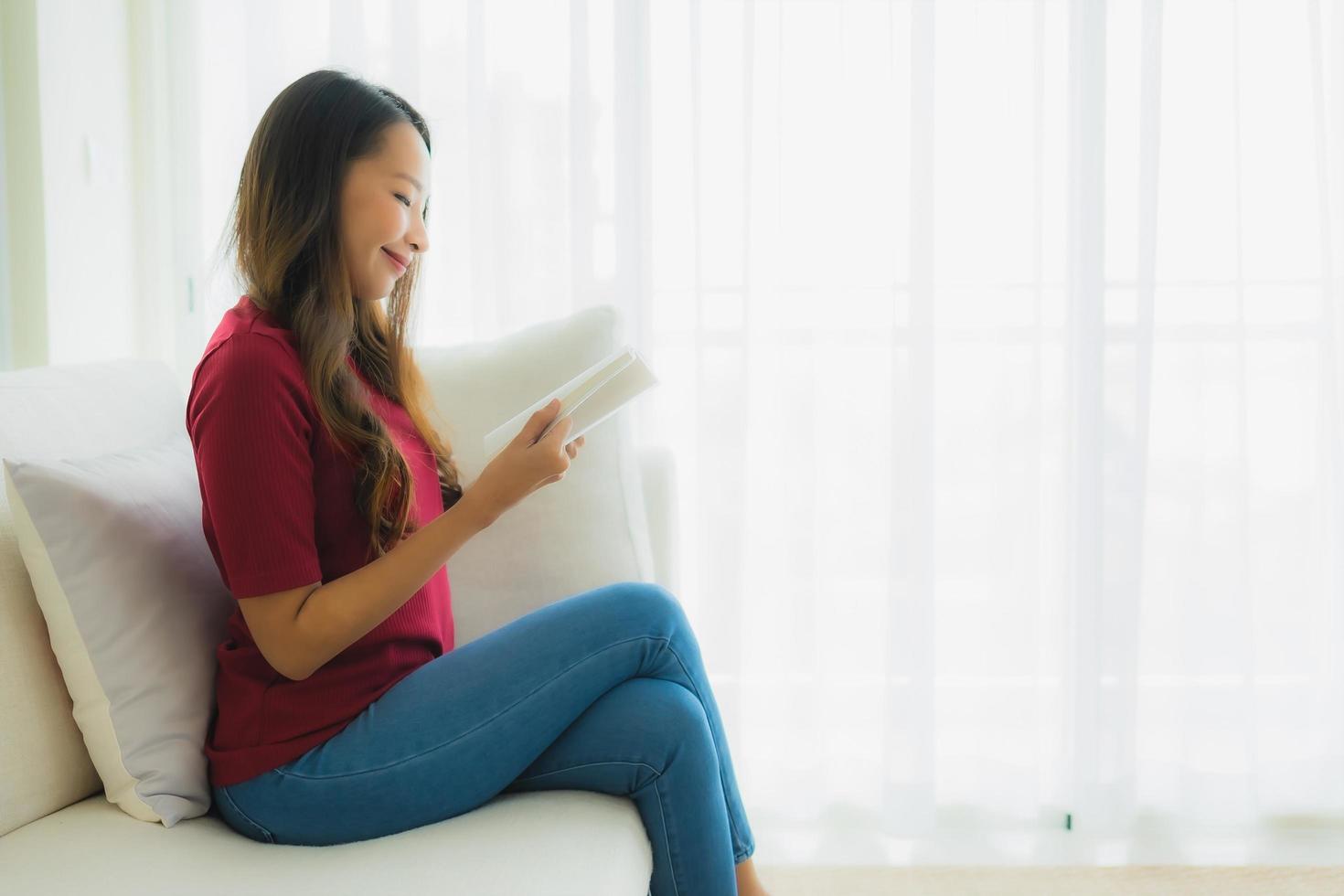 retrato, hermoso, joven, mujeres asiáticas, leer libro, en, sofá, sillón foto