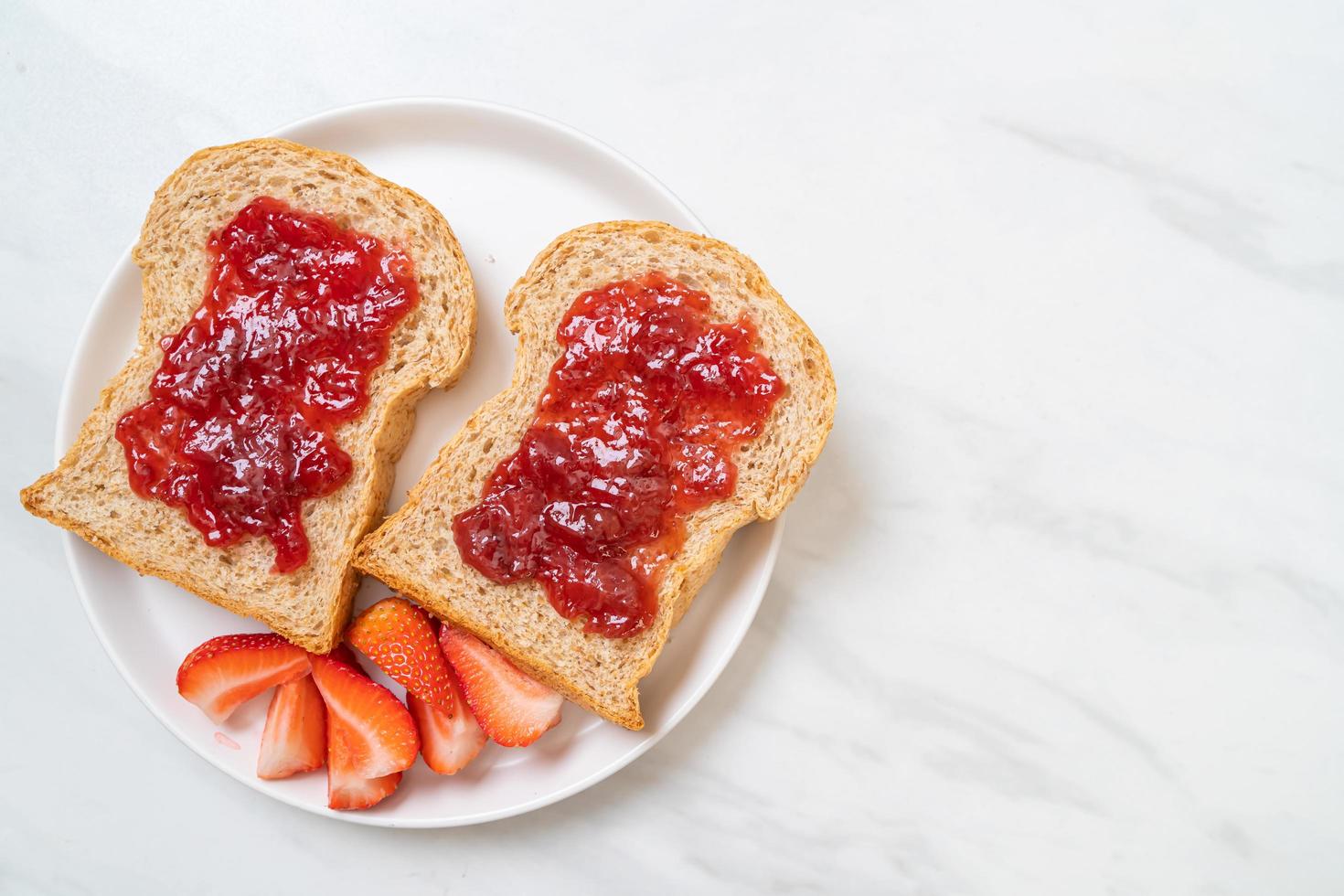 Homemade whole wheat bread with strawberry jam and fresh strawberry photo