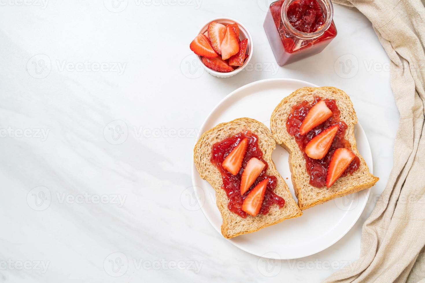 pan integral casero con mermelada de fresa y fresa fresca foto