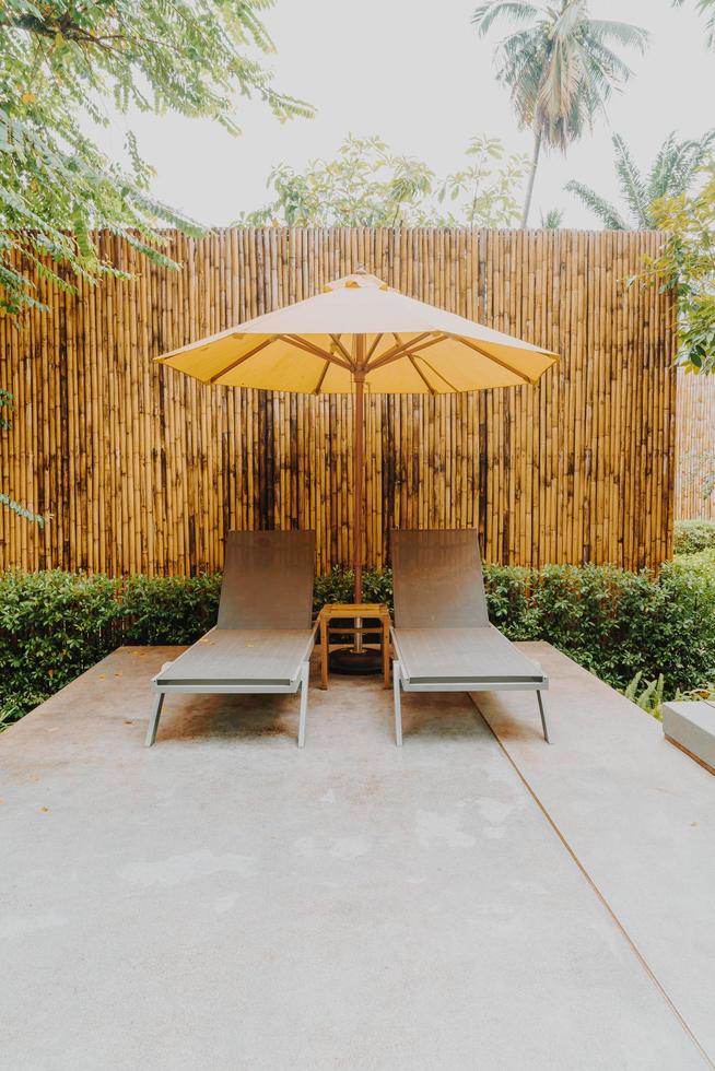 Umbrella and pool bed decoration around swimming pool in hotel resort photo