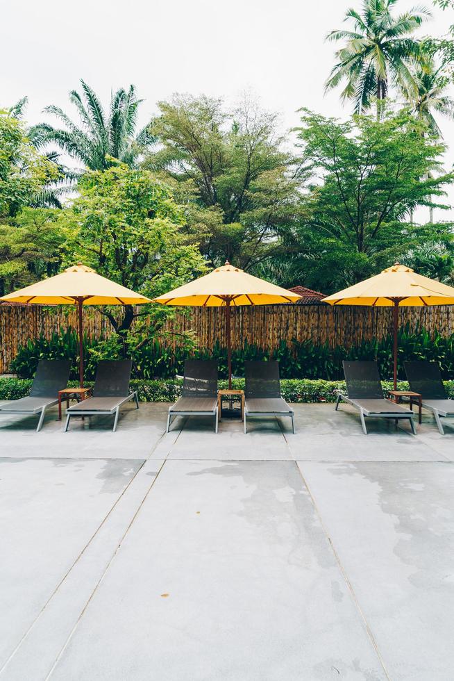 Umbrella and pool bed decoration around swimming pool in hotel resort photo