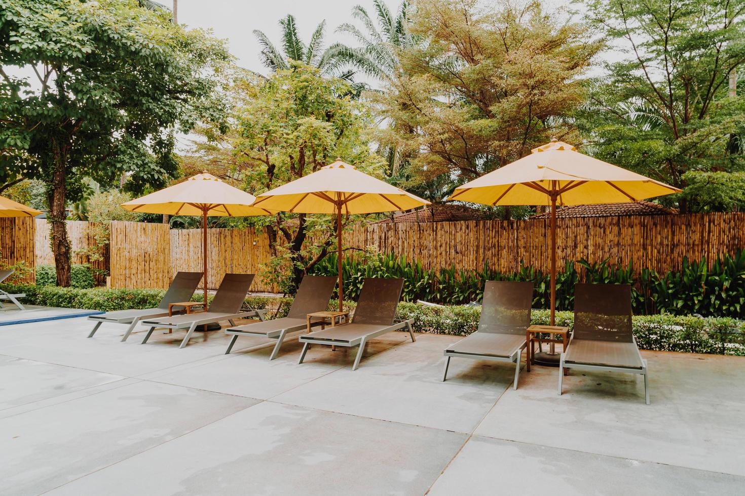 Umbrella and pool bed decoration around swimming pool in hotel resort photo