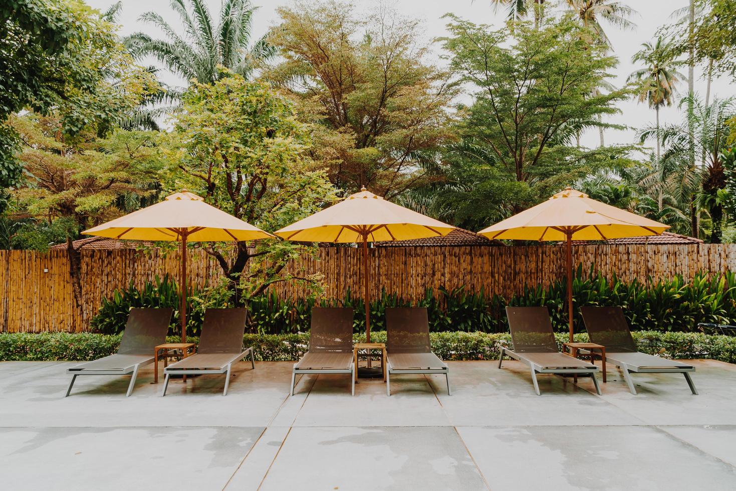 Umbrella and pool bed decoration around swimming pool in hotel resort photo