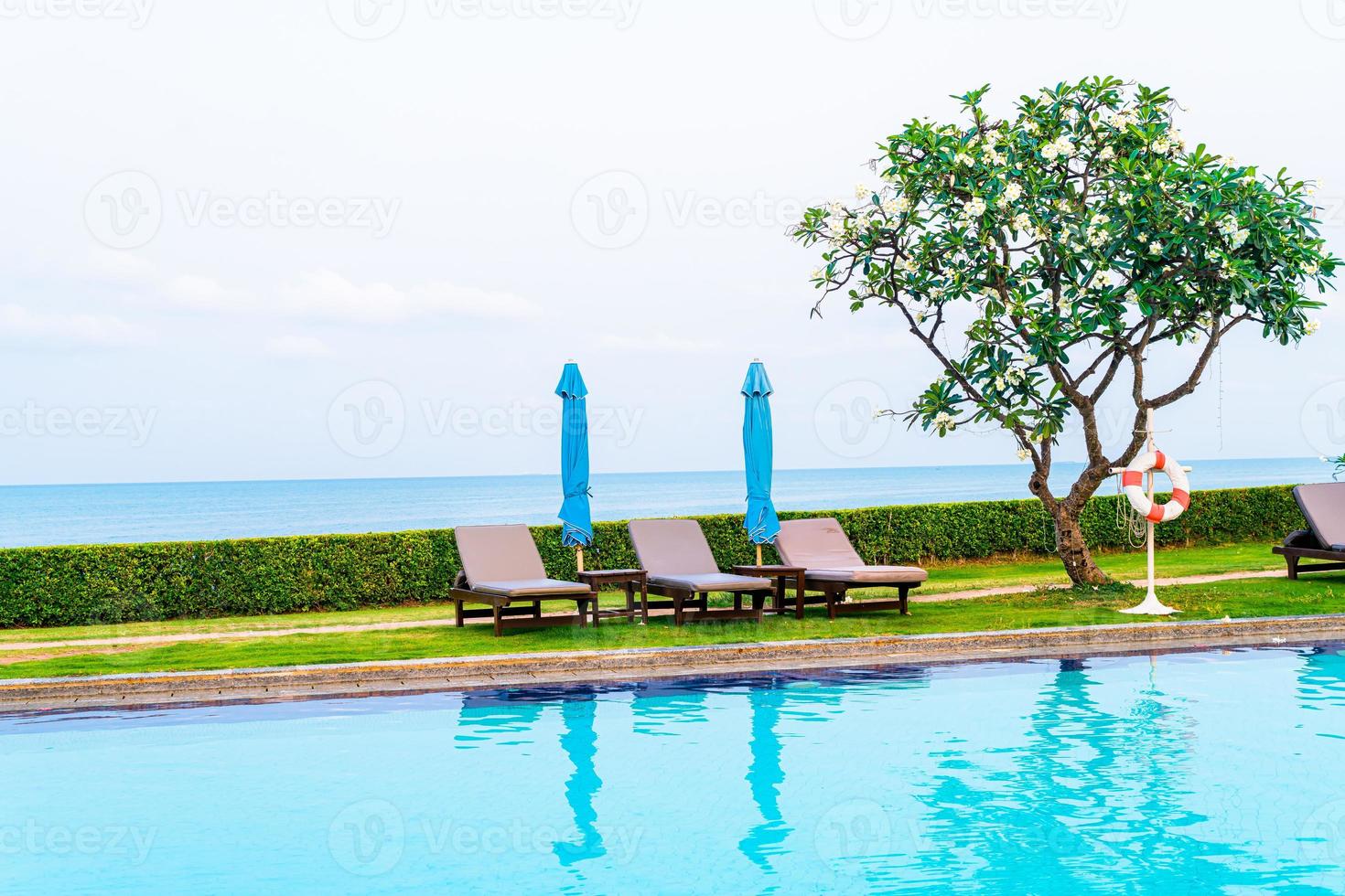 Chair pool or bed pool with umbrella around swimming pool photo