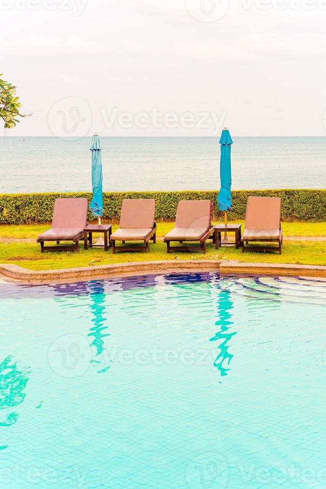 Chair pool or bed pool with umbrella around swimming pool photo