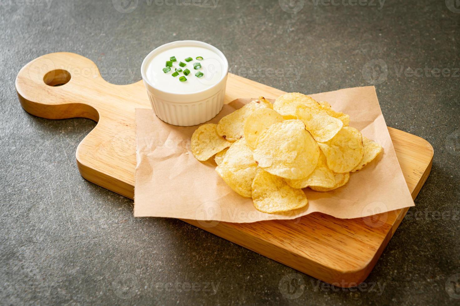 Potato chips with sour cream dipping sauce photo