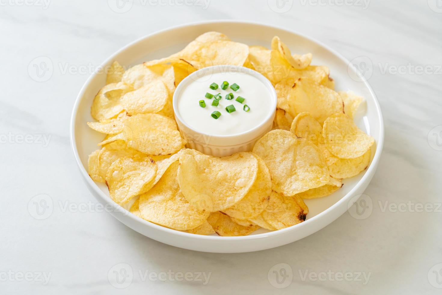 Potato chips with sour cream dipping sauce photo