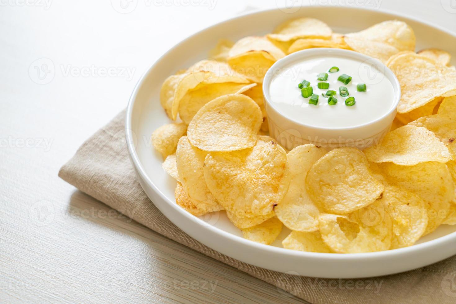 Potato chips with sour cream dipping sauce photo