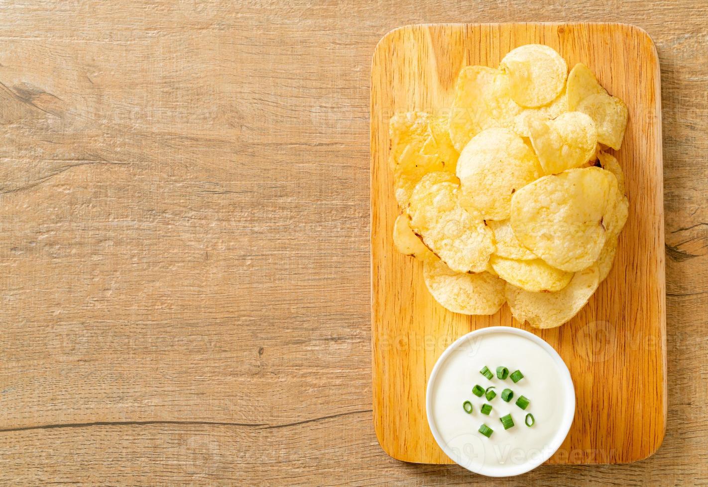 Potato chips with sour cream dipping sauce photo