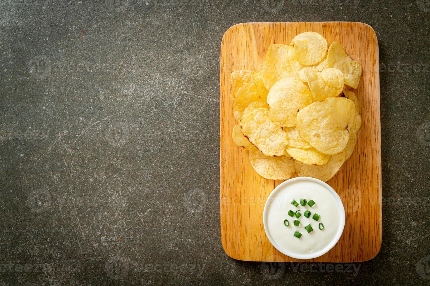 Potato chips with sour cream dipping sauce photo