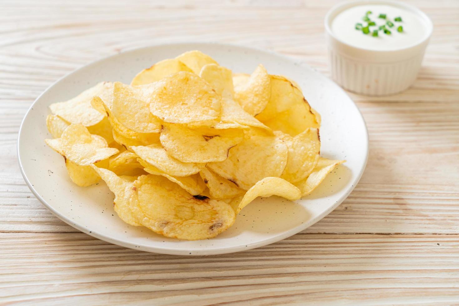 Potato chips with sour cream dipping sauce photo