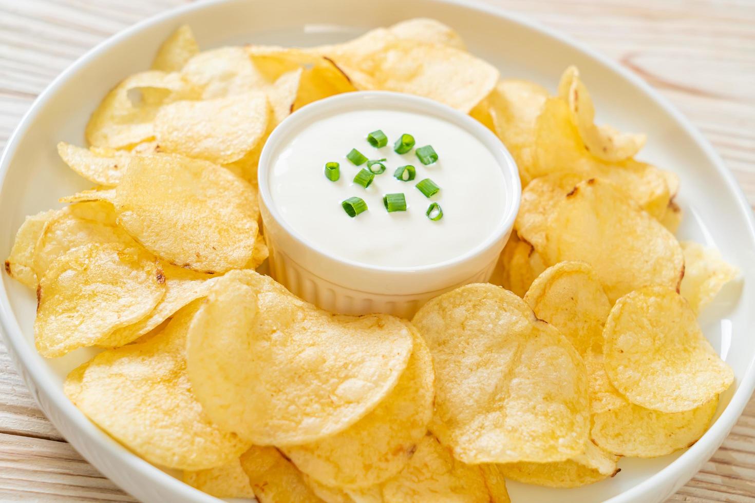 Potato chips with sour cream dipping sauce photo