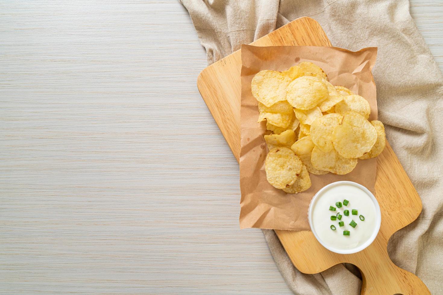 Potato chips with sour cream dipping sauce photo