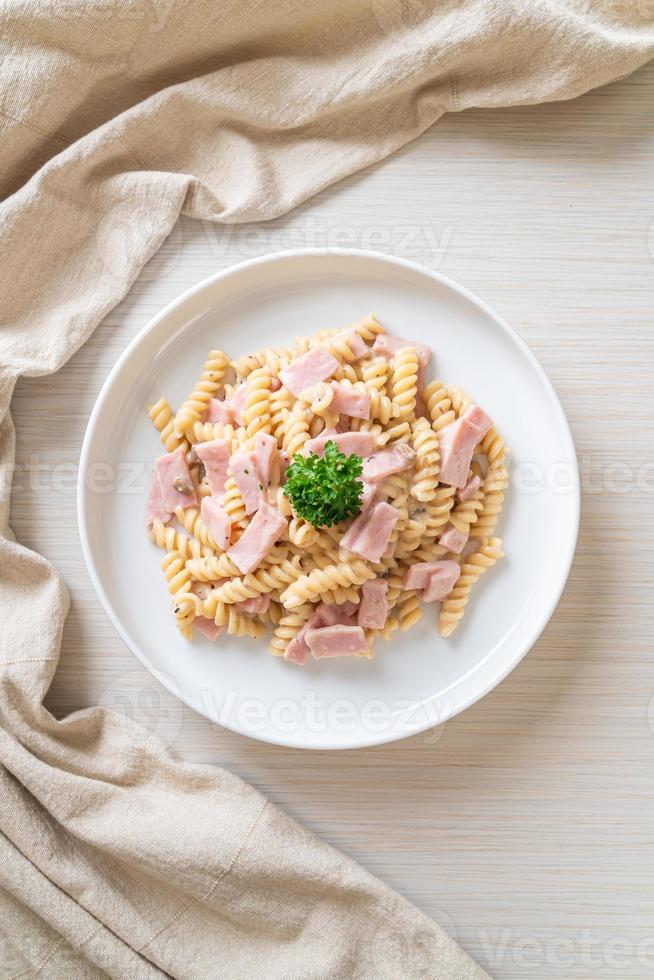 Spirali o salsa de crema de champiñones de pasta con jamón - estilo de comida italiana foto
