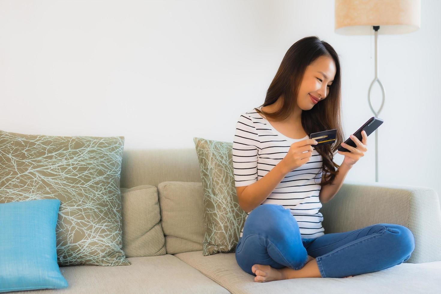 Retrato de hermosas mujeres asiáticas jóvenes con tarjeta de crédito, teléfono móvil o computadora para ir de compras foto