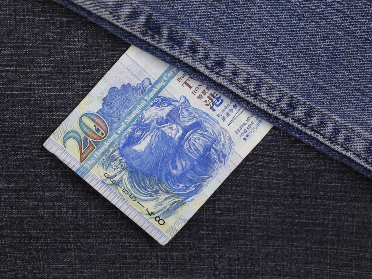 Hong Kong billete de veinte dólares entre tela de mezclilla azul foto